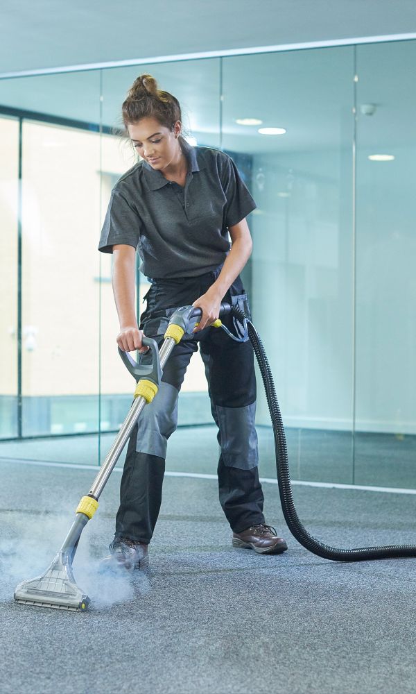 Woman steam cleaning office carpet